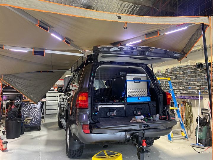 ARB 4x4 Accessories slide kitchen into the back of a 200 series Land Cruiser. Now ready for off-road touring with a fridge, awning, and lighting for the kitchen.